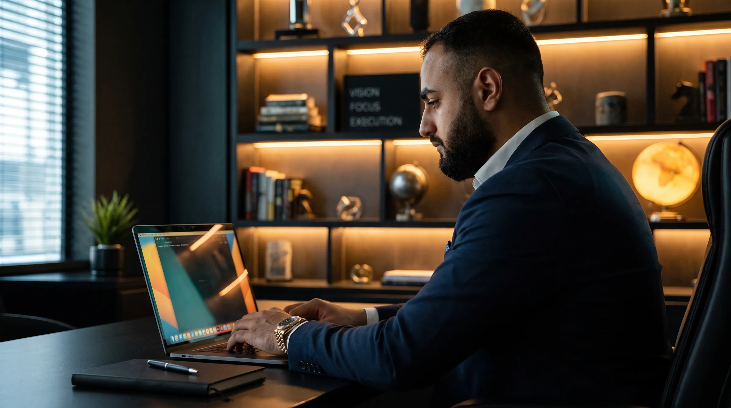 Hassan Pasha working at a laptop in his office, in profile