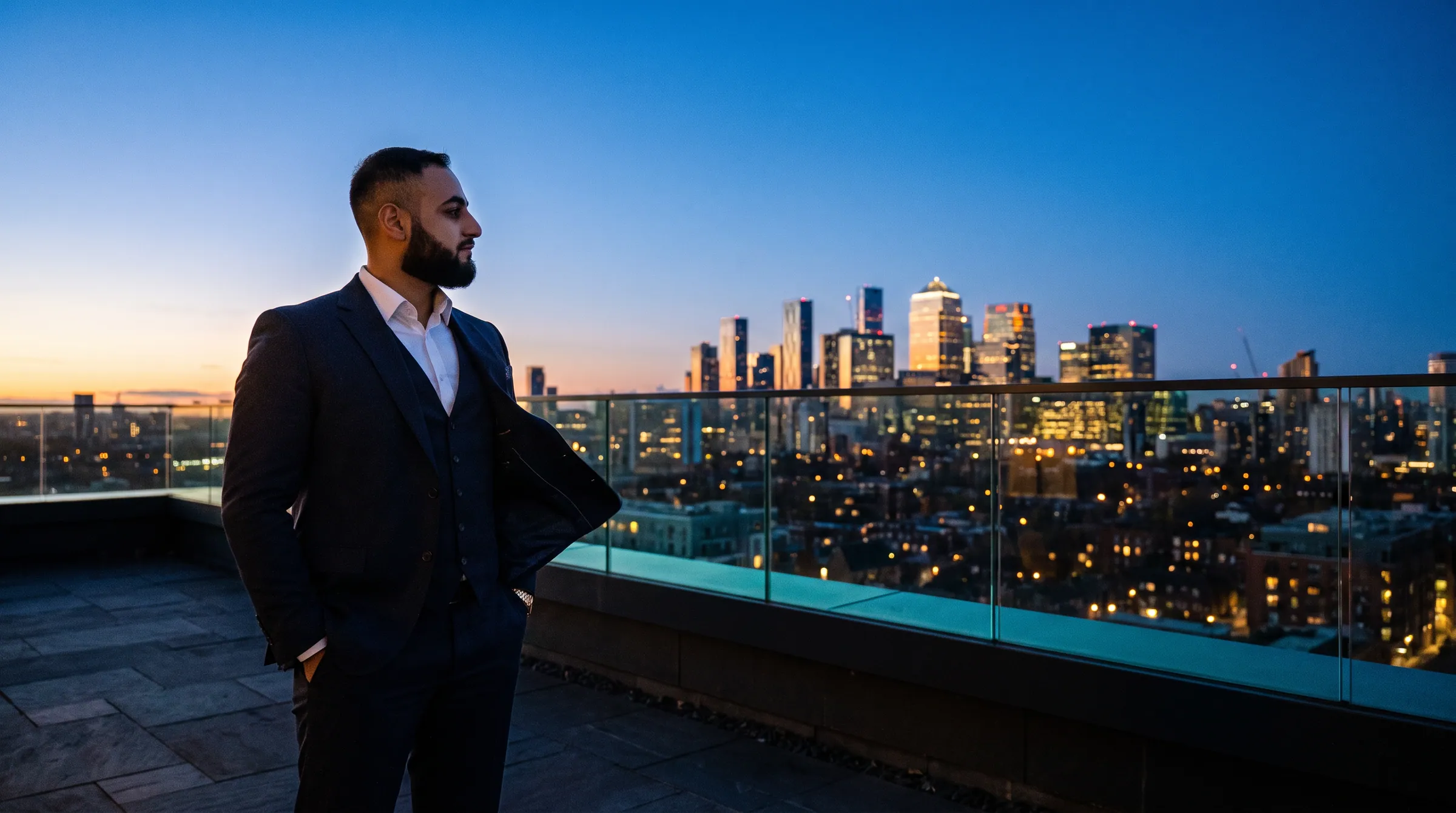 Hassan Pasha on a rooftop terrace at blue hour above the London skyline